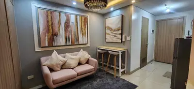 a living room with a couch and paintings on the wall at Perfect blend of home & comfort in Manila