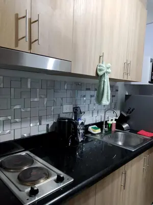 a kitchen counter with a sink and a stove at Perfect blend of home & comfort in Manila