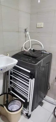 a washing machine in a bathroom next to a sink at Perfect blend of home & comfort in Manila