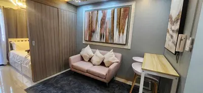 a living room with a pink chair and a table at Perfect blend of home & comfort in Manila
