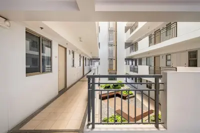 an empty hallway of an apartment building with plants at Coastal Inspired 2BR Condo I Fast Wi-Fi I Near BGC in Manila