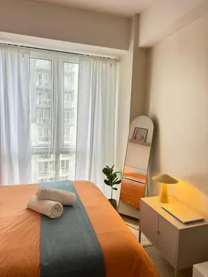 a bedroom with a bed and a large window at Mayas Home in Pasig Aesthetic and Cozy with Pool access and Netflix in Manila