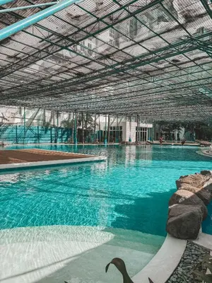 a large swimming pool with blue water in a building at Mayas Home in Pasig Aesthetic and Cozy with Pool access and Netflix in Manila