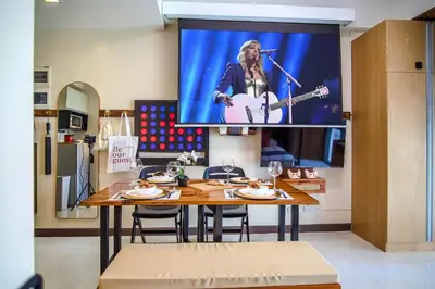a tv hanging on a wall above a dining room table at 1Up Retreat at BGC, Cinema Style near Mall in Manila