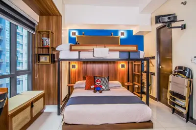a bedroom with two bunk beds in a room at 1Up Retreat at BGC, Cinema Style near Mall in Manila