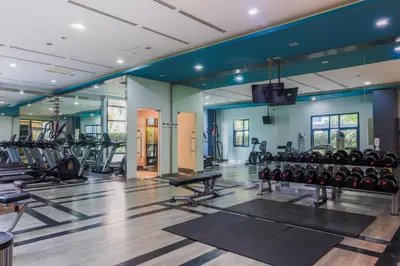a gym with a lot of treadmills and machines at 1Up Retreat at BGC, Cinema Style near Mall in Manila