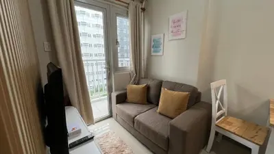 a living room with a couch and a window at UrbanEase Living at Charm Residences Near Sta Lucia Mall and Robinsons Mall in Manila
