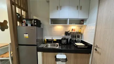 a small kitchen with a sink and a refrigerator at UrbanEase Living at Charm Residences Near Sta Lucia Mall and Robinsons Mall in Manila