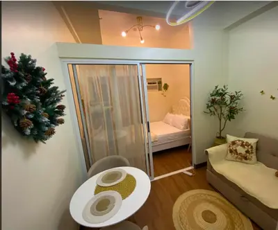 a small living room with a table and a couch at La Mari 1 bedroom at Prisma Residences in Manila