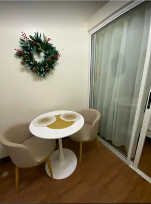 a room with a table and chairs and a wreath on the wall at La Mari 1 bedroom at Prisma Residences in Manila