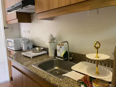 a kitchen counter with a sink and a microwave at La Mari 1 bedroom at Prisma Residences in Manila