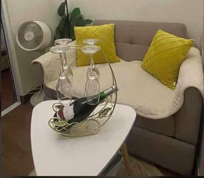 a bottle of wine on a table next to a couch at La Mari 1 bedroom at Prisma Residences in Manila