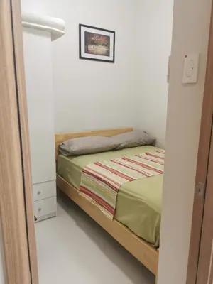 a small bedroom with a bed and a mirror at Mall of Asia Pasay Shore 3 tower condotel in Manila