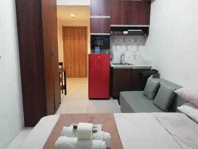 a kitchen and a living room with a red refrigerator at Manila Condotel near US Embassy in Manila