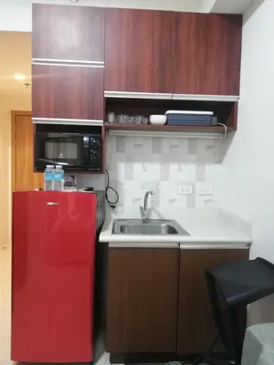 a kitchen with a sink and a red refrigerator at Manila Condotel near US Embassy in Manila