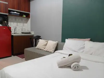a hotel room with two beds and a couch at Manila Condotel near US Embassy in Manila