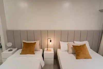 two beds sitting next to each other in a bedroom at Shore 2 Residences in Manila