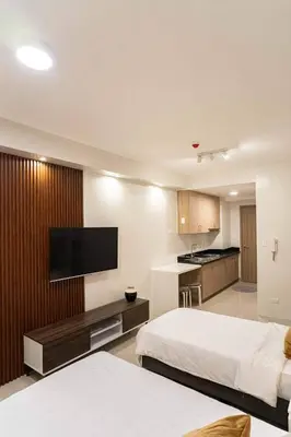 a hotel room with two beds and a flat screen tv at Shore 2 Residences in Manila
