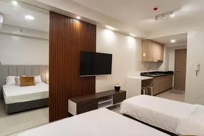 a hotel room with two beds and a flat screen tv at Shore 2 Residences in Manila