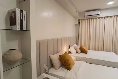 a small room with two beds and a window at Shore 2 Residences in Manila