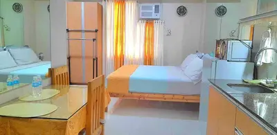 a bedroom with a bed and a kitchen with a sink at 101 Newport Boulevard in Manila