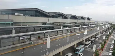 a highway with cars parked in front of a building at 101 Newport Boulevard in Manila