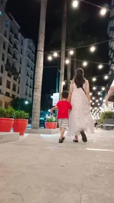 a woman and a child walking down a sidewalk at 101 Newport Boulevard in Manila