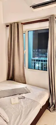 a bedroom with a window with a view of a city at 1 BR Condo with Balcony in Manila