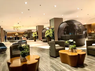 a hotel lobby with couches and tables and flowers at 1 BR Condo with Balcony in Manila