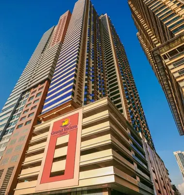 a tall building with a sign in front of it at Grand Riviera suite Condotel Near SLEC in Manila