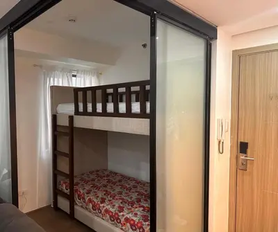 a bedroom with two bunk beds and a sliding glass door at Aya's Place Two Bedrooms near MOA in Manila