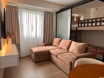 a living room with a couch and a bed at Aya's Place Two Bedrooms near MOA in Manila