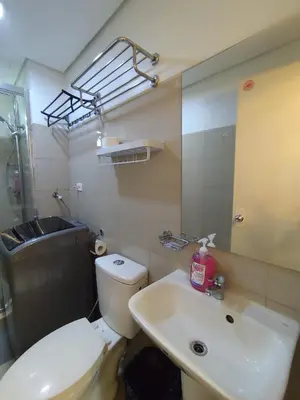 a bathroom with a toilet and a sink and a mirror at Aya's Place Two Bedrooms near MOA in Manila
