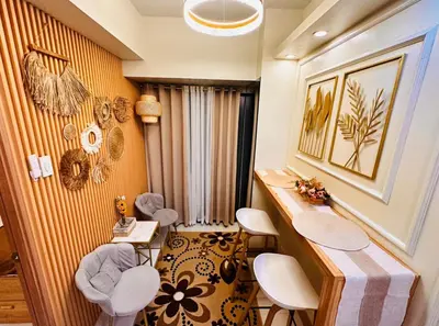 a room with chairs and a table and a wall at Kendra Suite at Shore 3 Residences, MOA in Manila