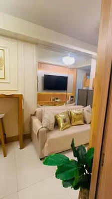 a living room with a couch and a television at Kendra Suite at Shore 3 Residences, MOA in Manila