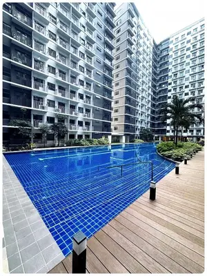 a swimming pool in front of a large apartment building at Kendra Suite at Shore 3 Residences, MOA in Manila