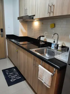 a kitchen with a sink and a counter top at Cozy Shore Residence with balcony near Mall of Asia & airport in Manila