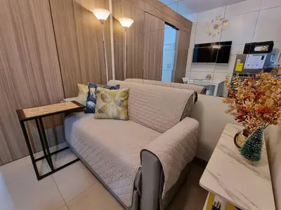 a living room with a couch and a table at Cozy Shore Residence with balcony near Mall of Asia & airport in Manila