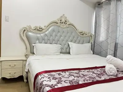a bedroom with a large bed with a large headboard at \u65e5\u843d\u6d77\u6e7e\u516c\u9986 in Manila