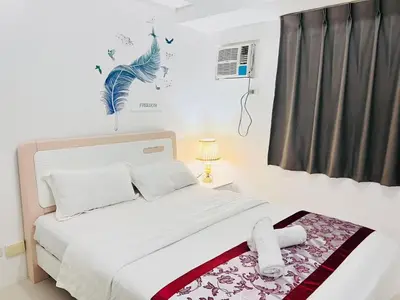 a white bedroom with a bed and a window at \u65e5\u843d\u6d77\u6e7e\u516c\u9986 in Manila