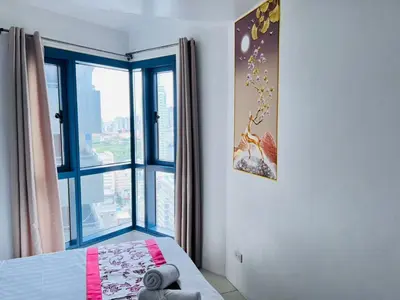 a bedroom with a bed and a large window at \u65e5\u843d\u6d77\u6e7e\u516c\u9986 in Manila