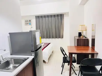 a kitchen with a refrigerator and a table and a bed at \u65e5\u843d\u6d77\u6e7e\u516c\u9986 in Manila
