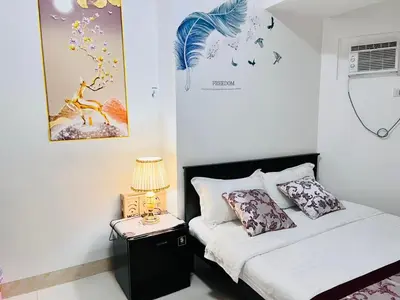 a bedroom with a bed and a table with a lamp at \u65e5\u843d\u6d77\u6e7e\u516c\u9986 in Manila
