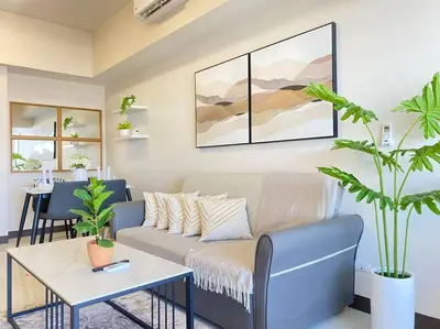 a living room with a couch and a table at BGC Skyline 2BR Suite with Parking in Uptown BGC in Manila