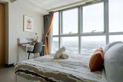 a bedroom with a bed with a stuffed animal on it at BGC Skyline 2BR Suite with Parking in Uptown BGC in Manila