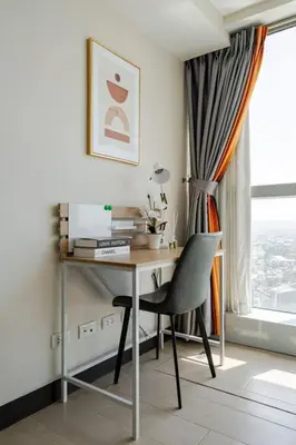 a desk with a chair in a room with a window at BGC Skyline 2BR Suite with Parking in Uptown BGC in Manila
