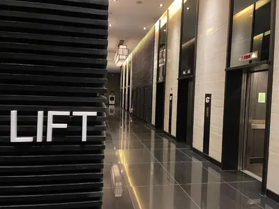 a hallway in a building with a lift sign on the wall at Destina at Air Residences, Makati, Metro Manila in Manila