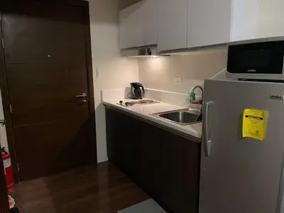 a small kitchen with a sink and a refrigerator at Destina at Air Residences, Makati, Metro Manila in Manila