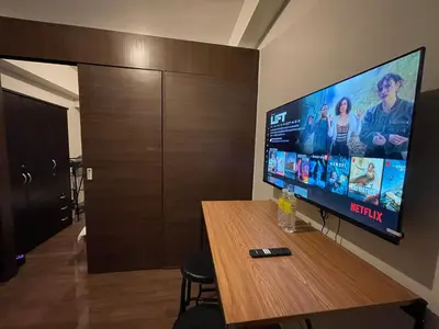 a room with a table and a flat screen tv at Destina at Air Residences, Makati, Metro Manila in Manila