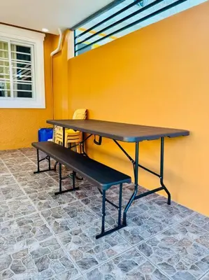a table and a bench against a yellow wall at La Prima - The Perfect Urban Oasis in Santa Rosa
